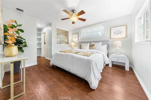 bedroom featuring visible vents, baseboards, a ceiling fan, and wood finished floors