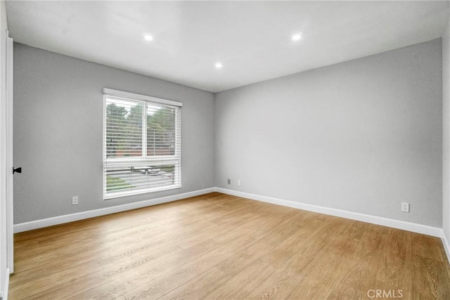 empty room with recessed lighting, baseboards, and light wood-style flooring