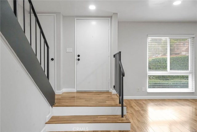 stairway featuring recessed lighting, baseboards, and wood finished floors