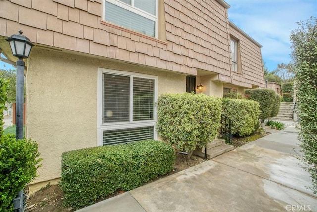 property entrance featuring a patio and stucco siding