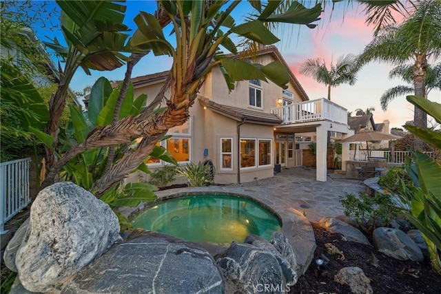 view of pool featuring outdoor dry bar, a patio, and an in ground hot tub