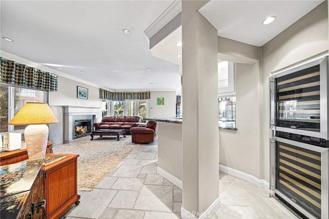 interior space with a high end fireplace, baseboards, stone tile flooring, and beverage cooler