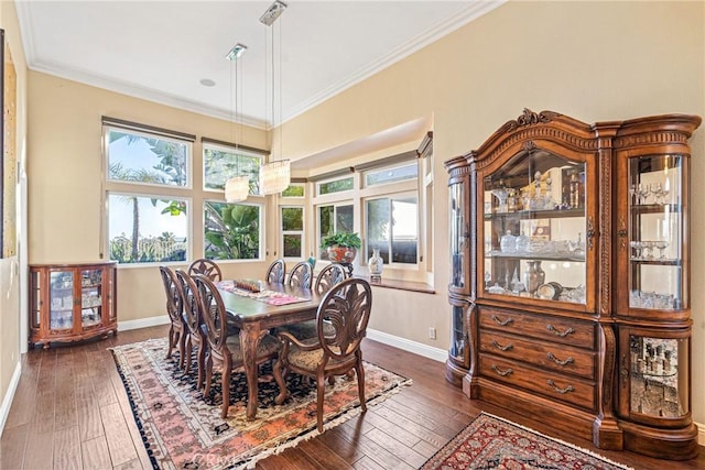 dining room with crown molding, baseboards, and dark wood finished floors
