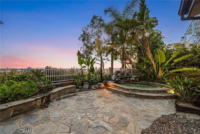 patio terrace at dusk with a fenced backyard