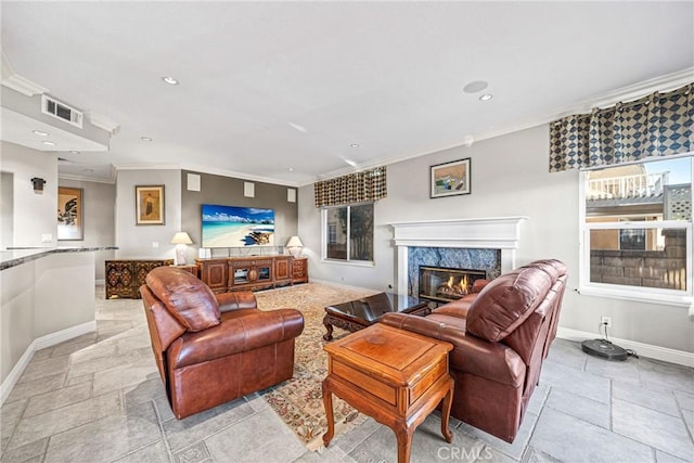 living area featuring baseboards, stone tile floors, and crown molding