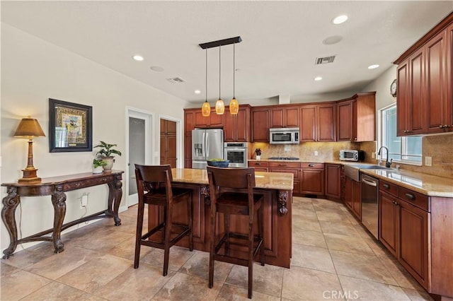 18181 Lost Creek Rd, Saugus, CA 91390 - kitchen with stainless steel appliances, a sink, backsplash, a center island, and light stone countertops