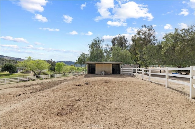 view of stable featuring a rural view and a mountain view