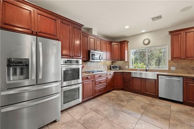 kitchen featuring tasteful backsplash, recessed lighting, visible vents, appliances with stainless steel finishes, and a sink