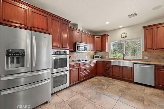 18181 Lost Creek Rd, Saugus, CA 91390 - kitchen with stainless steel appliances, decorative backsplash, recessed lighting, brown cabinetry, and light tile patterned flooring