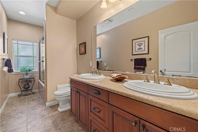 full bathroom with toilet, enclosed tub / shower combo, double vanity, and a sink
