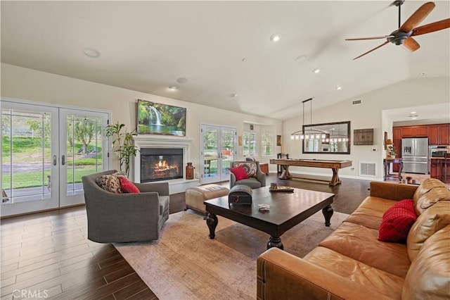 living area featuring visible vents, french doors, a wealth of natural light, and vaulted ceiling