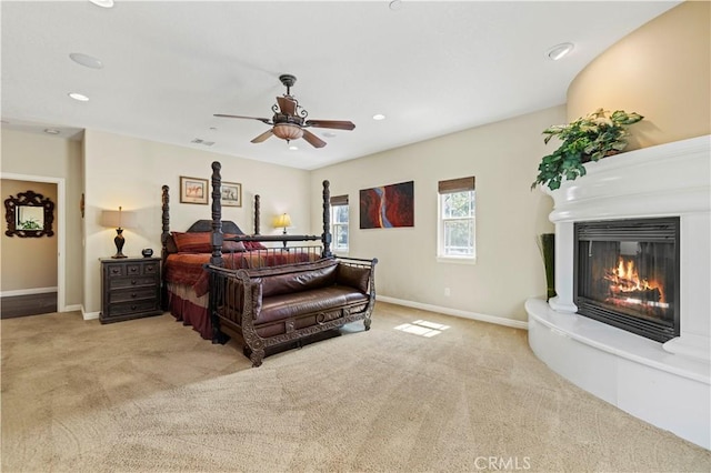 bedroom with a glass covered fireplace, baseboards, recessed lighting, carpet floors, and visible vents