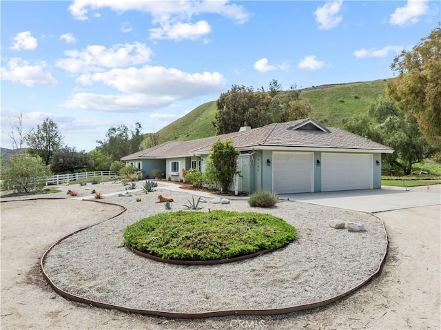 single story home with an attached garage, driveway, fence, and stucco siding