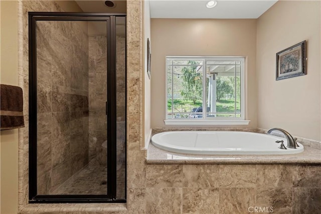 full bathroom with a shower stall and a bath
