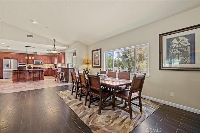 dining room with visible vents, baseboards, recessed lighting, light wood finished floors, and vaulted ceiling