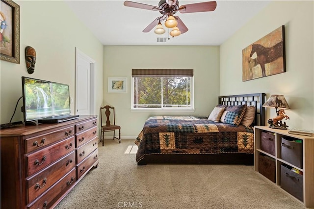 carpeted bedroom with baseboards, a ceiling fan, and visible vents