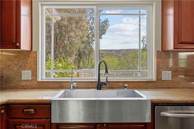 kitchen with tasteful backsplash, dishwasher, light countertops, and a sink