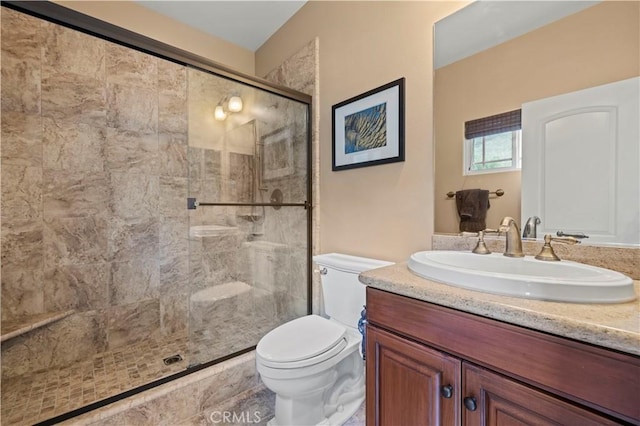 full bathroom with toilet, a shower stall, and vanity