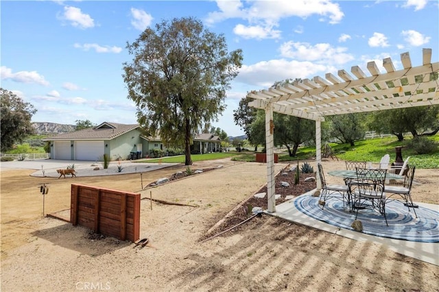 view of yard featuring a pergola and concrete driveway