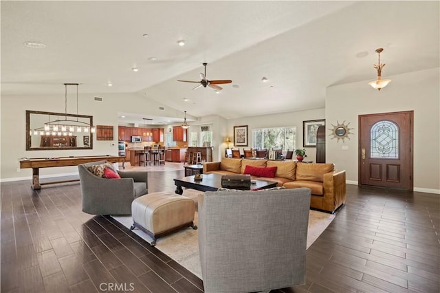 living area with dark wood-type flooring, lofted ceiling, and plenty of natural light