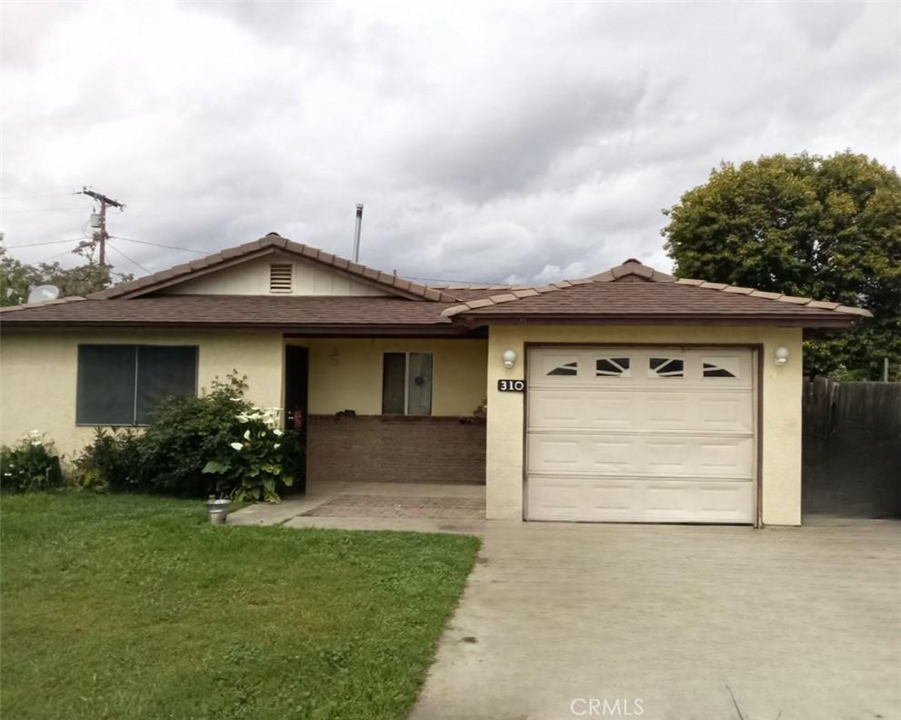 single story home featuring driveway, stucco siding, a front yard, and an attached garage