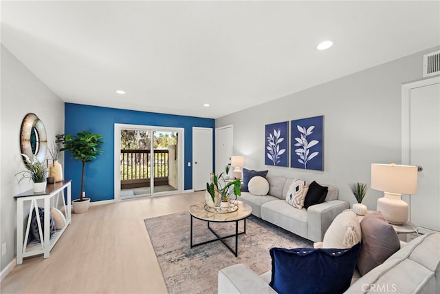 living room with baseboards, wood finished floors, and recessed lighting