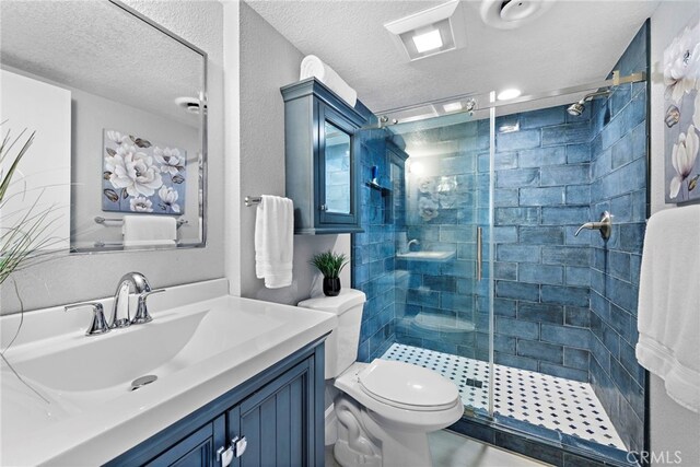 bathroom with toilet, vanity, a textured ceiling, and a shower stall