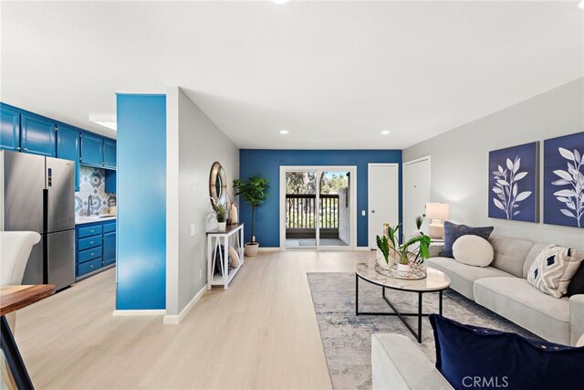 living area featuring light wood-style flooring, baseboards, and recessed lighting