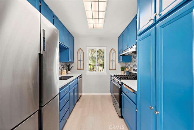 kitchen featuring under cabinet range hood, blue cabinets, and stainless steel appliances