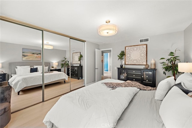 bedroom featuring wood finished floors, a closet, and visible vents