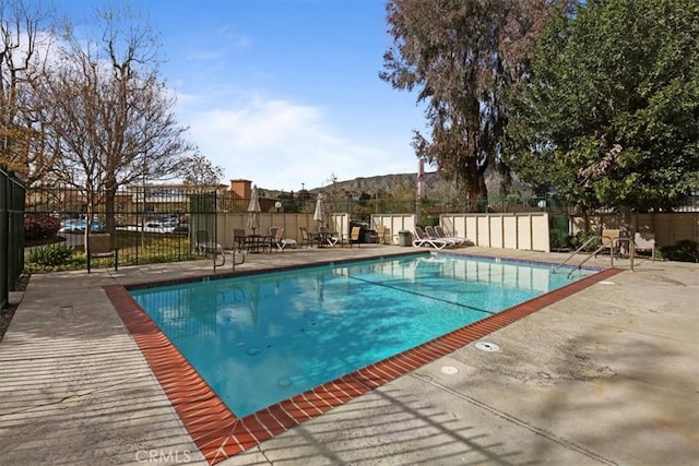 view of swimming pool featuring a patio, fence, and a fenced in pool