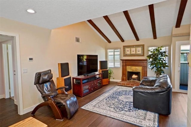 living room with visible vents, lofted ceiling with beams, baseboards, and a warm lit fireplace