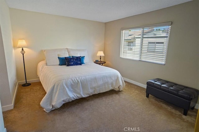 bedroom featuring baseboards, carpet flooring, and a textured ceiling