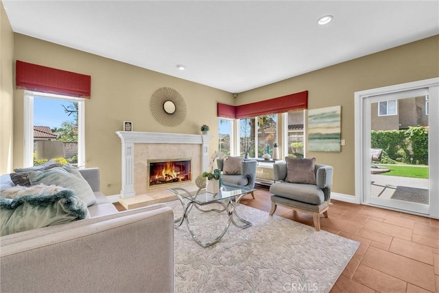living area featuring a wealth of natural light, a premium fireplace, recessed lighting, and baseboards
