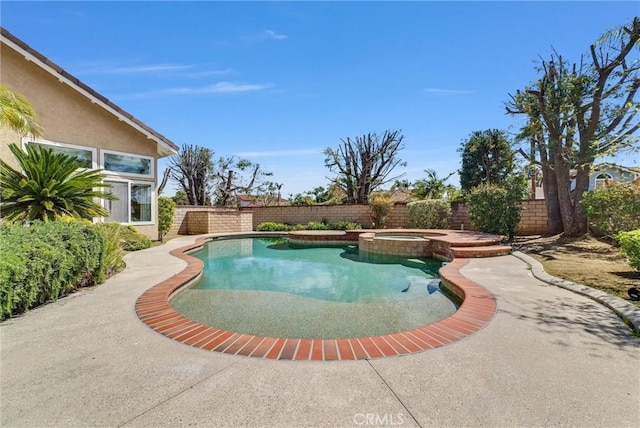 view of swimming pool featuring a patio area, a pool with connected hot tub, and a fenced backyard
