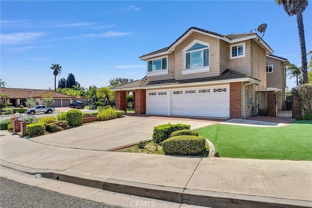 traditional-style house featuring concrete driveway, a front lawn, an attached garage, and a gate