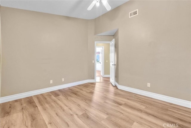 spare room with a ceiling fan, visible vents, light wood-style flooring, and baseboards