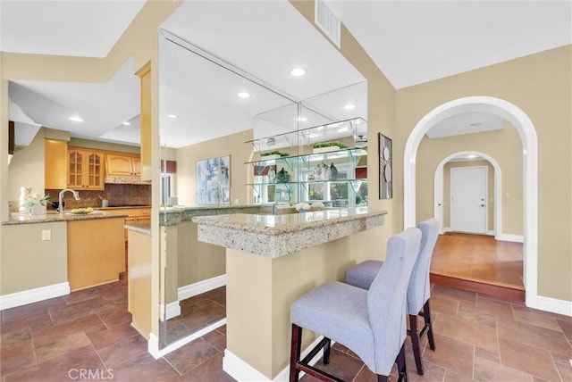 interior space with baseboards, recessed lighting, backsplash, stone tile floors, and visible vents