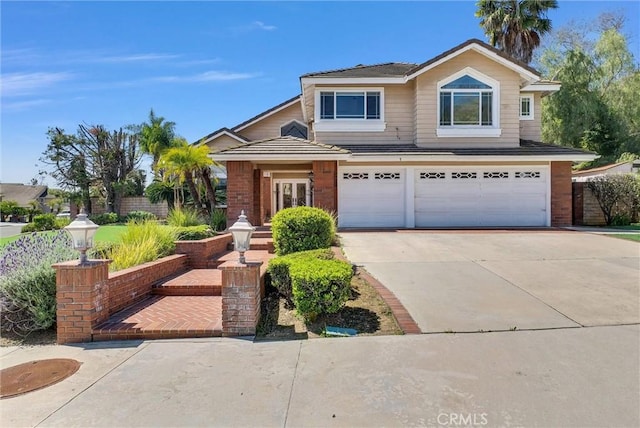 traditional-style home featuring concrete driveway, a garage, brick siding, and fence
