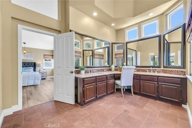 ensuite bathroom with recessed lighting, baseboards, connected bathroom, and vanity