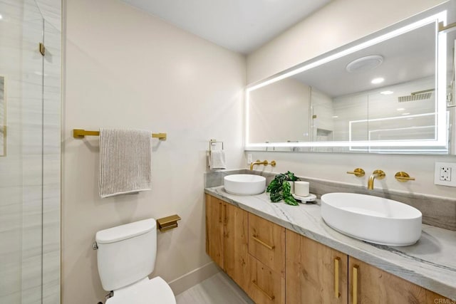 bathroom featuring a tile shower, toilet, baseboards, and a sink