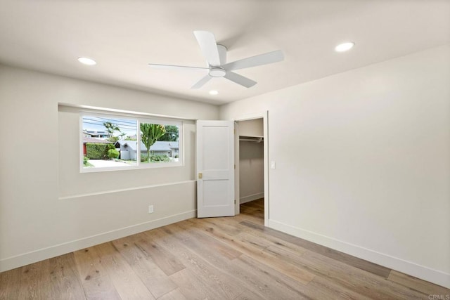 unfurnished bedroom featuring baseboards, a ceiling fan, and light wood-style flooring