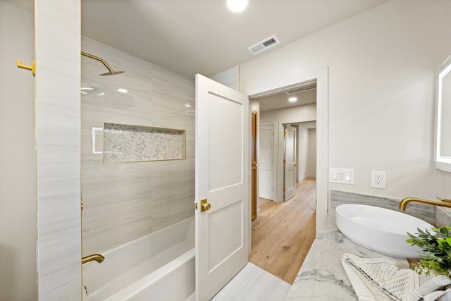 full bathroom featuring wood finished floors, visible vents, recessed lighting, and a sink