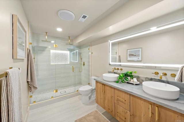full bathroom featuring visible vents, toilet, double vanity, and a sink