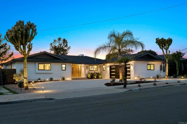 ranch-style home with driveway, a garage, and stucco siding