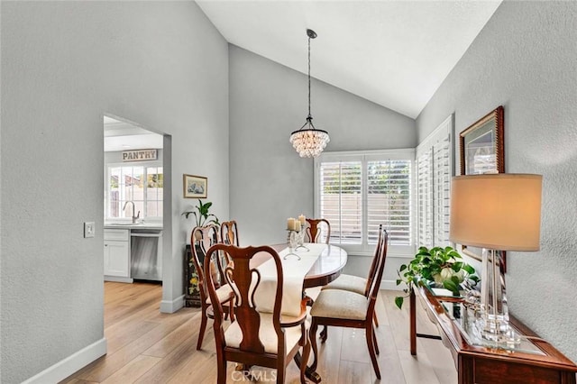 9 Las Piedras, Rancho Santa Margarita, CA 92688 - dining room featuring high vaulted ceiling, a chandelier, light wood-type flooring, baseboards, and a textured wall