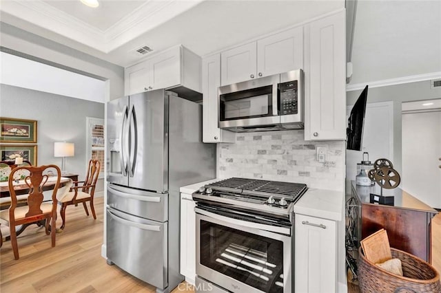 9 Las Piedras, Rancho Santa Margarita, CA 92688 - kitchen featuring stainless steel appliances, visible vents, white cabinets, decorative backsplash, and ornamental molding