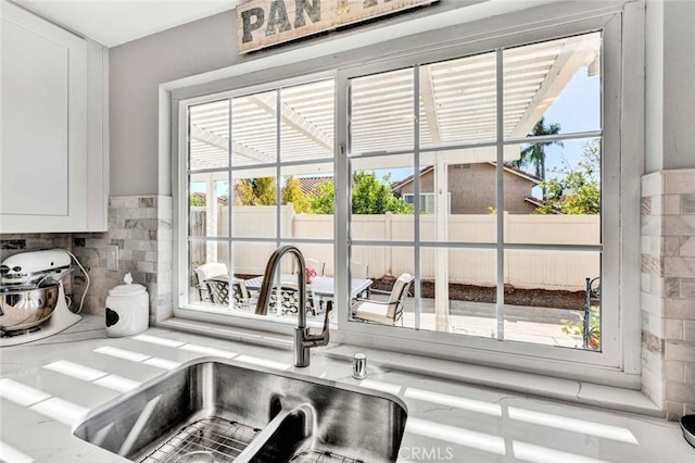 9 Las Piedras, Rancho Santa Margarita, CA 92688 - room details featuring white cabinets, decorative backsplash, a sink, and light countertops