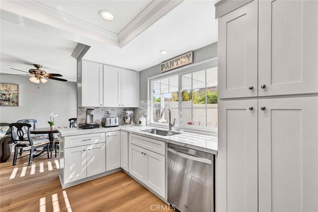 9 Las Piedras, Rancho Santa Margarita, CA 92688 - kitchen featuring light countertops, a tray ceiling, ornamental molding, stainless steel dishwasher, and a sink