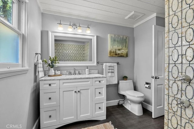 bathroom with crown molding, toilet, vanity, wood finished floors, and baseboards